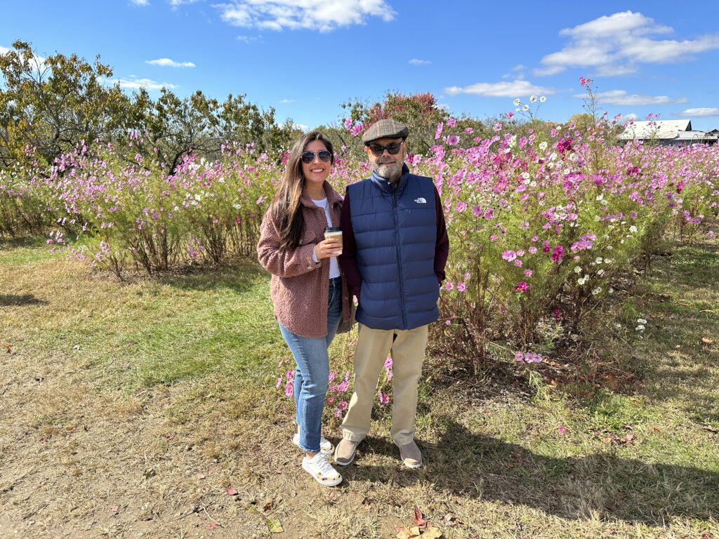 woman and man standing outside an orchard with sunglasses on