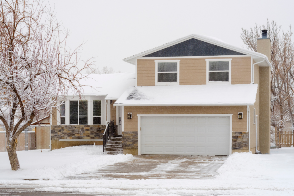 two story home with brick and siding in the winter, snow is on the ground and the driveway is shoveled