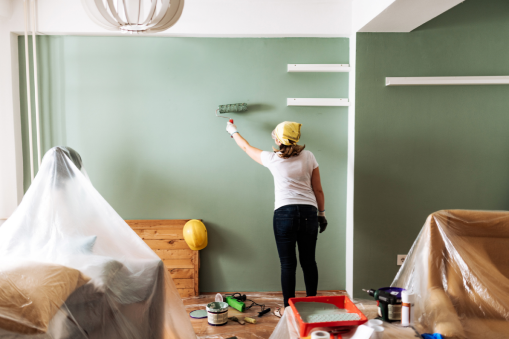 woman painting the walls inside her home a relaxing green shade