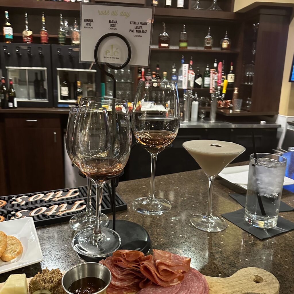 charcuterie board, wine glasses, and an espresso martini on a bar top